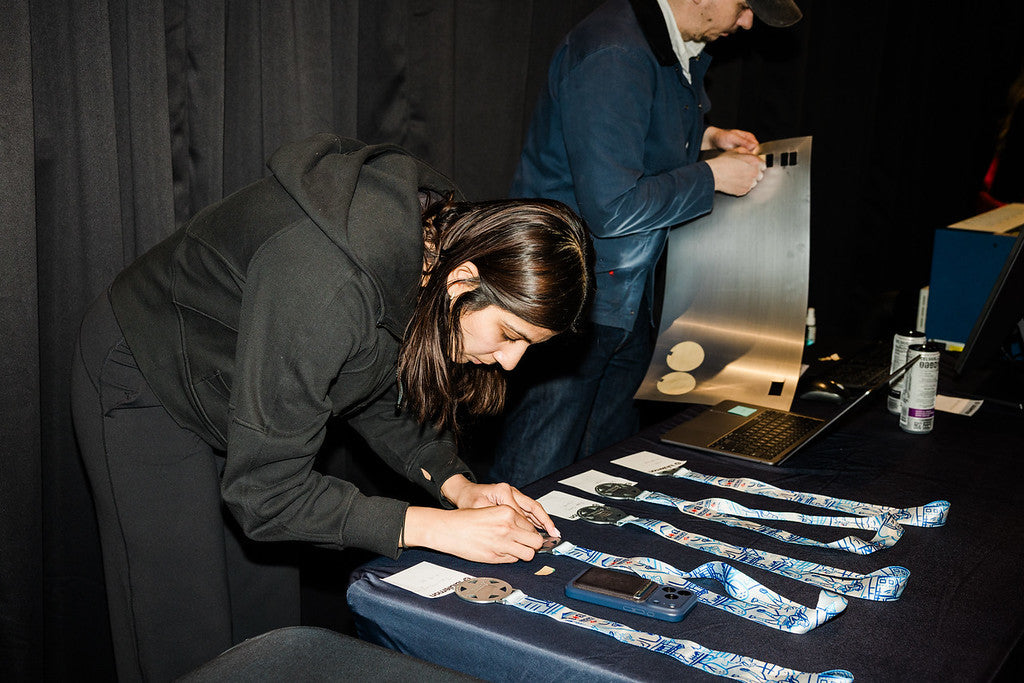 Live finisher-medal engraving at the Lululemon Chicago Distance Series activation — names and times engraved at the bench